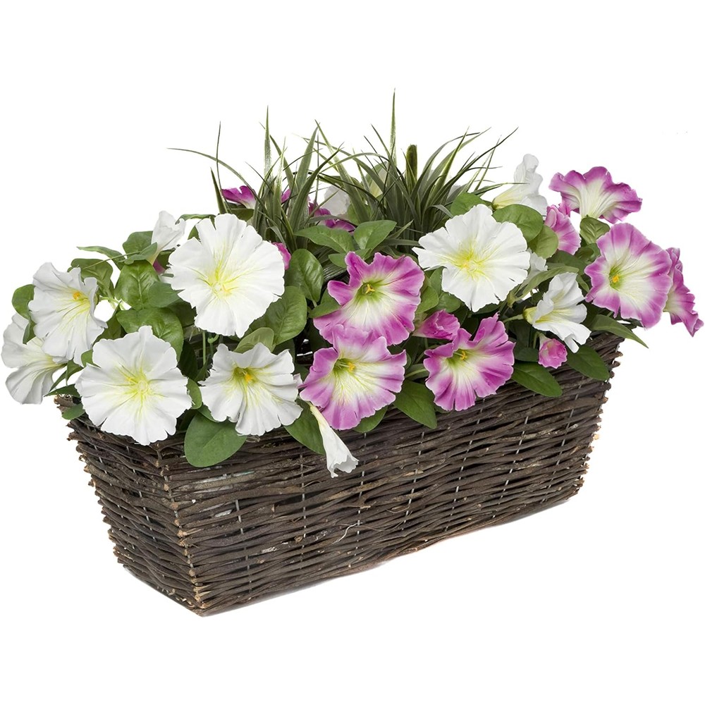 Pink and white artificial petunias and green grasses in a rectangular rattan window box