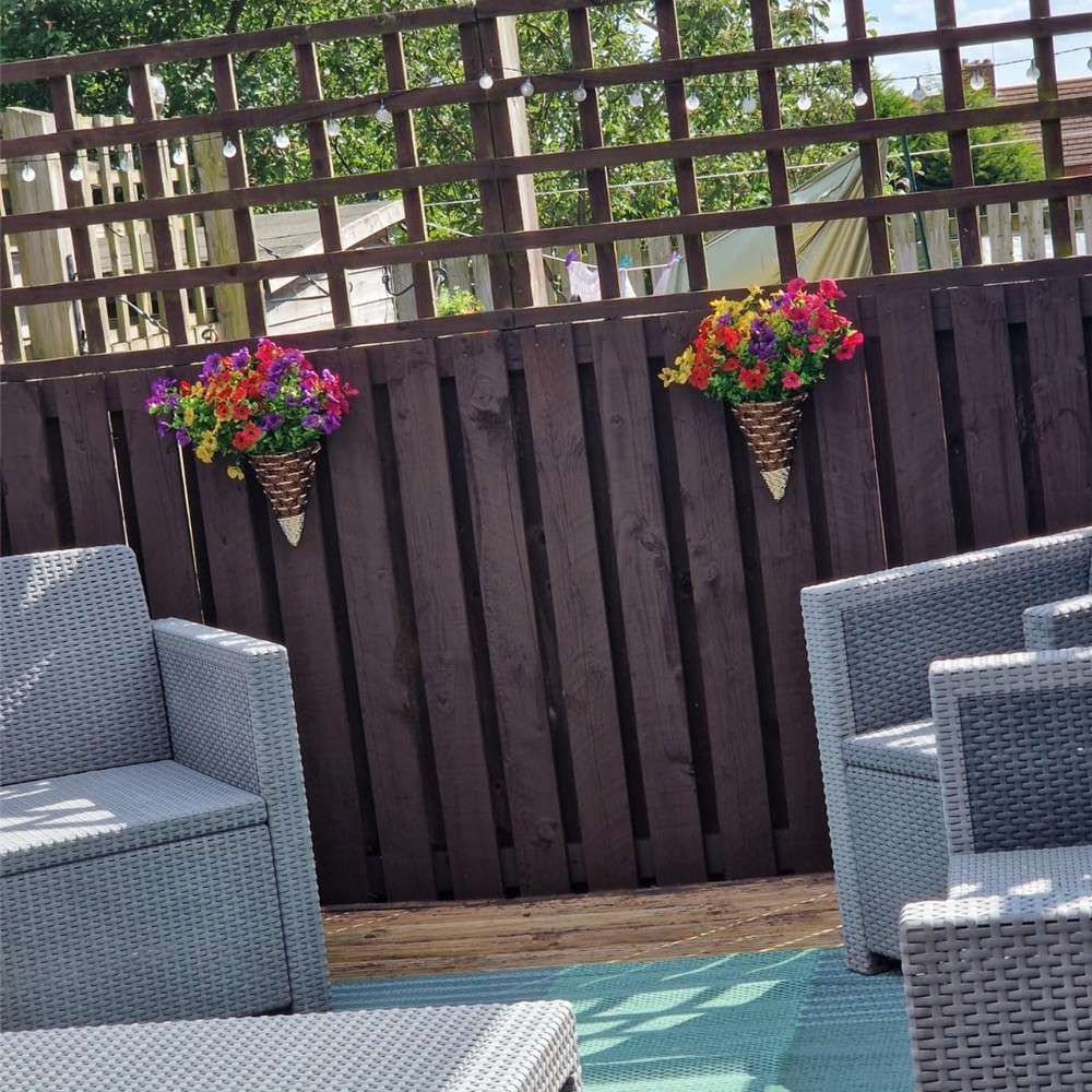 Customer photo showing the pair of colourful cone wall baskets on a garden fence