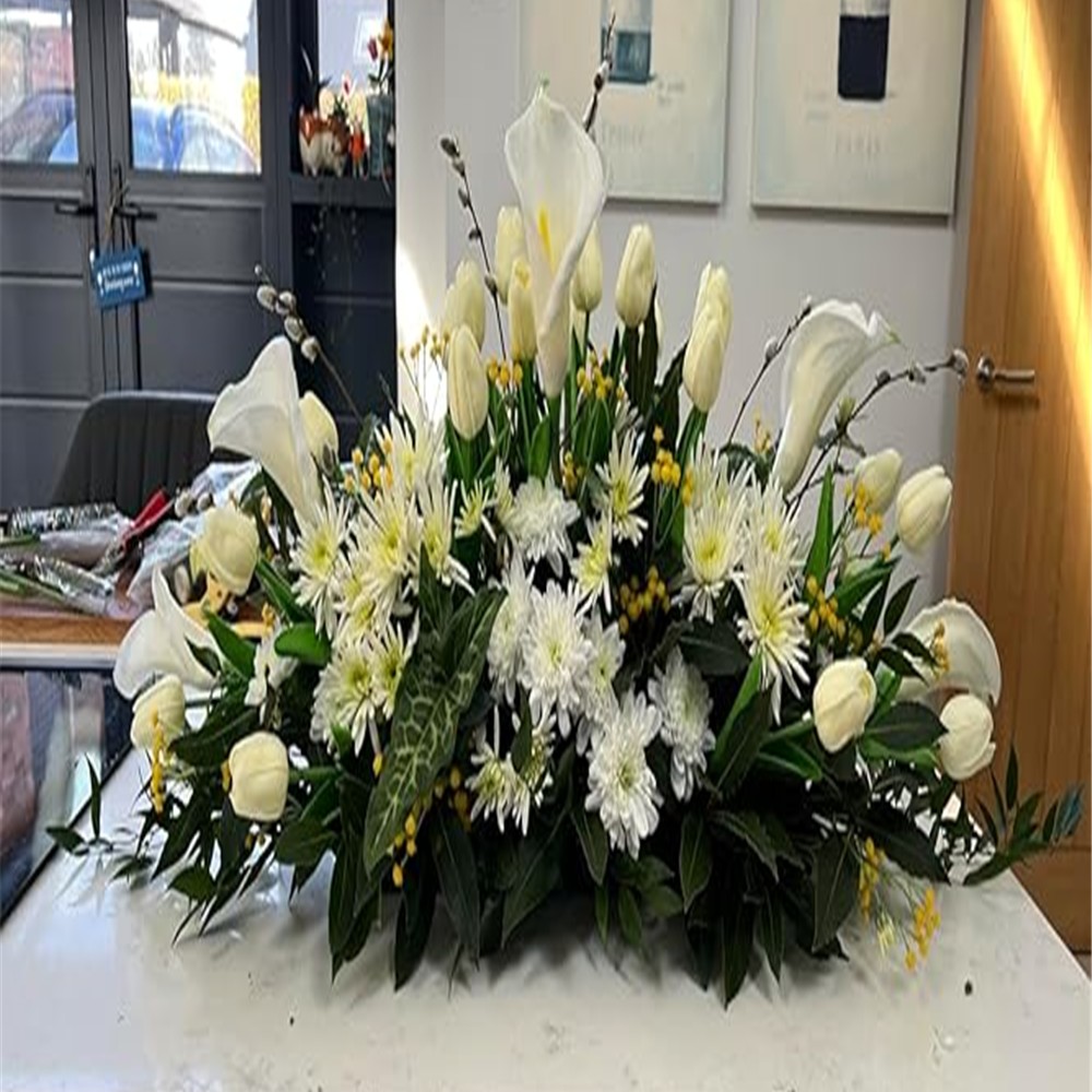 Customer floral arrangement with white calla lilies, tulips and greenery