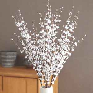 Tall white artificial jasmine sprays arranged in a white vase
