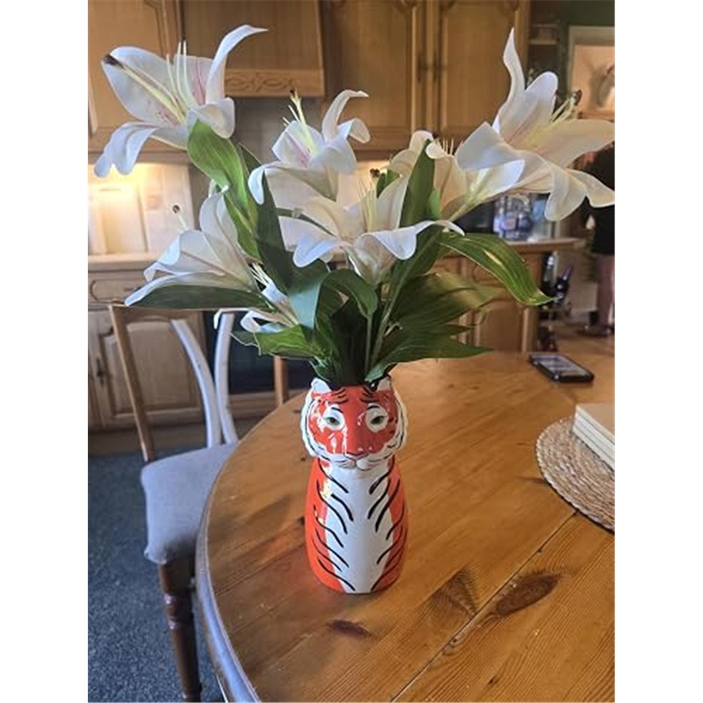 Customer display of champagne-white lilies in a colourful tall vase