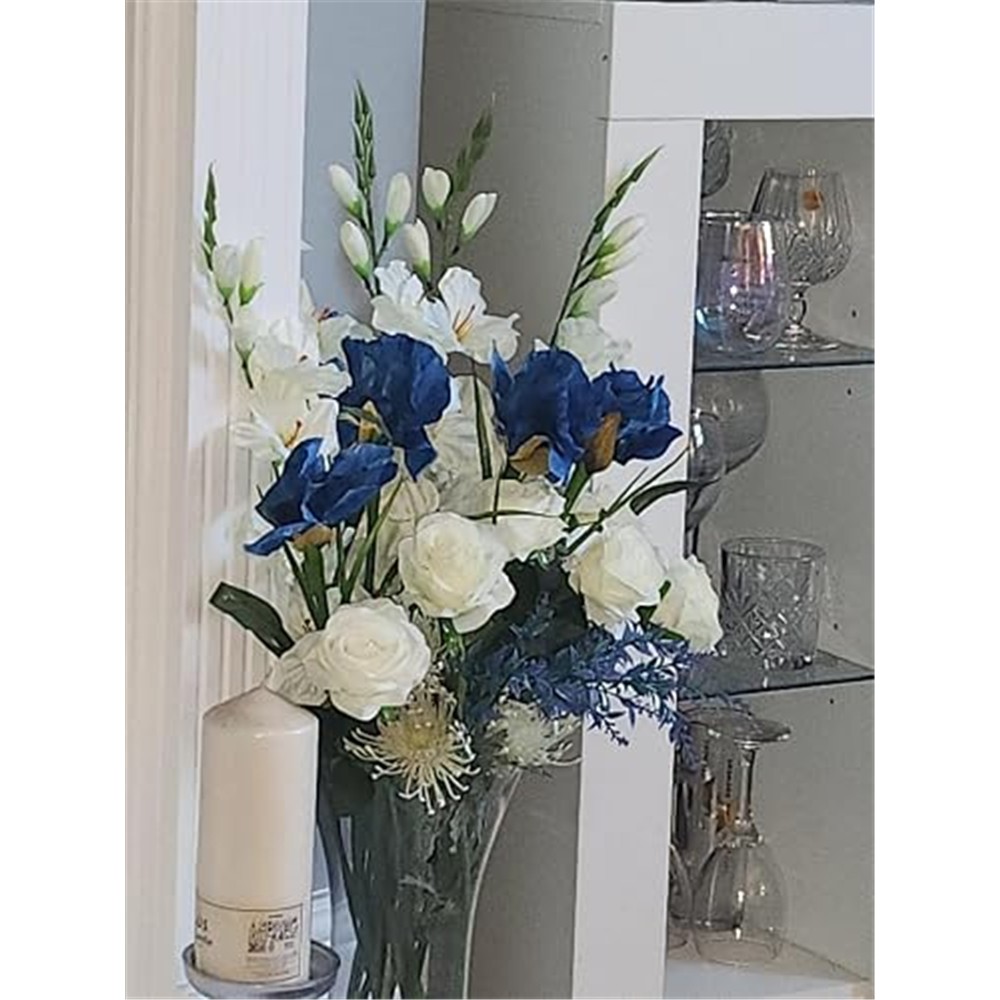 Blue artificial irises in a customer arrangement with white flowers and green foliage