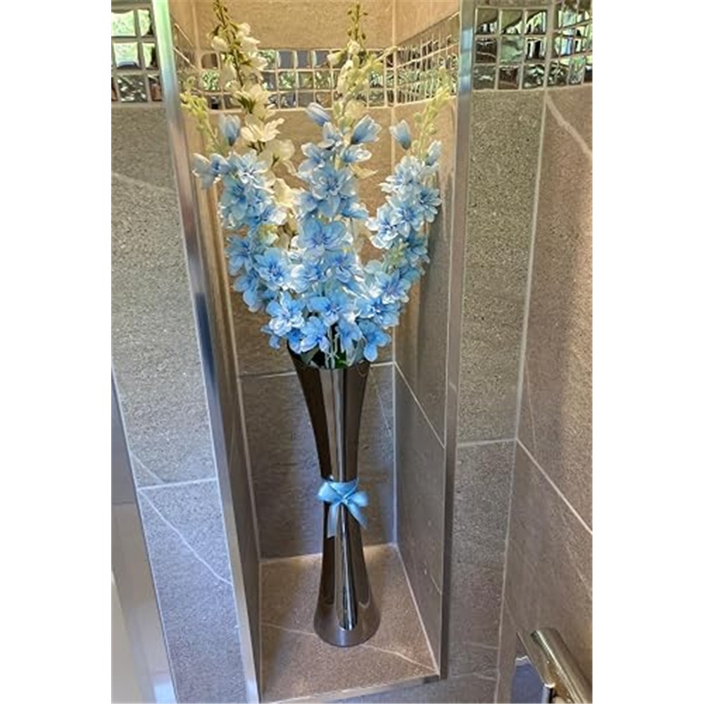 Customer display of pale blue delphiniums with white flowers in a tall vase