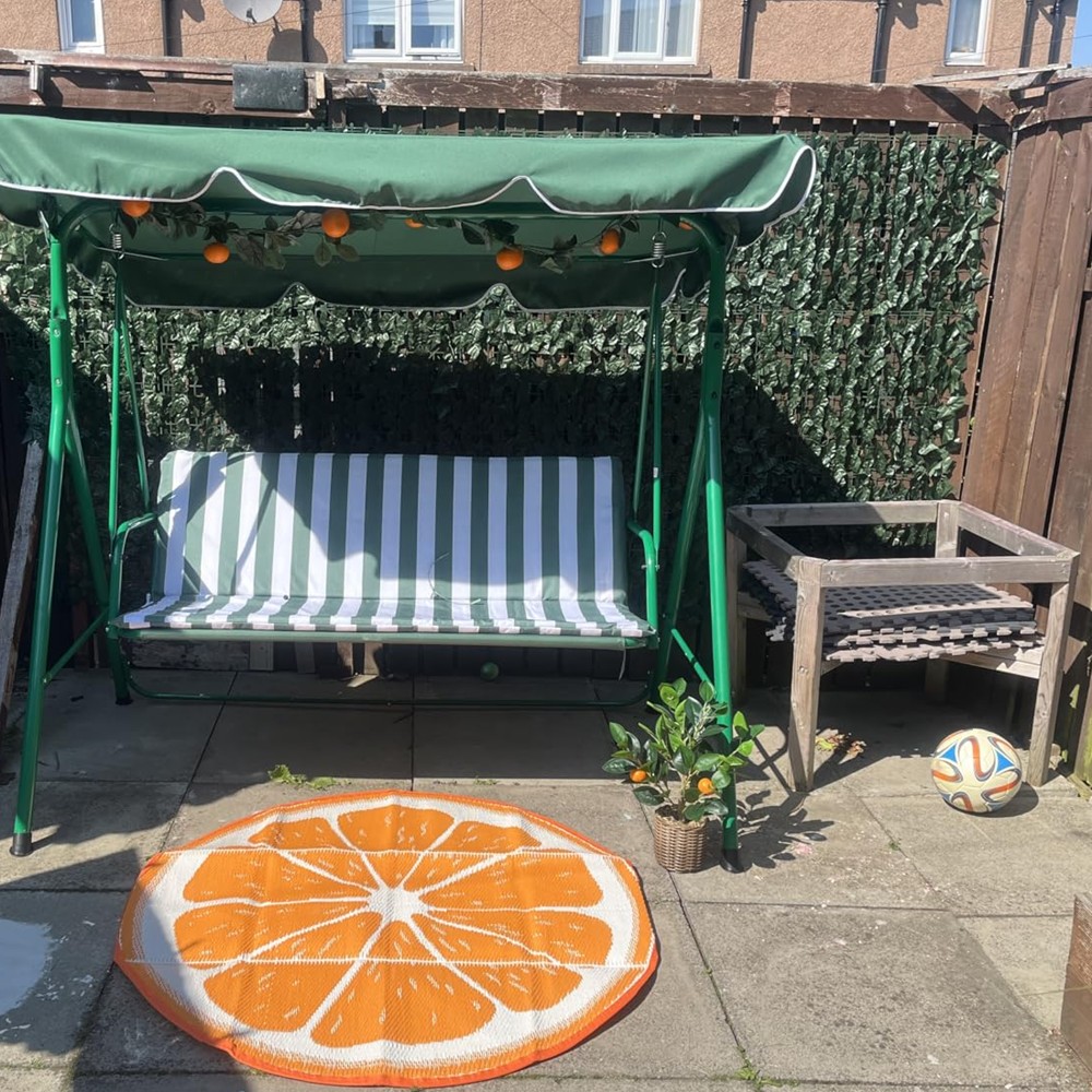 Customer garden display with artificial ivy behind a swing seat