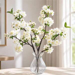 White artificial cherry blossom branches shown in a clear styling vase