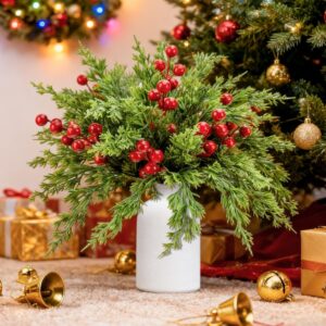 Christmas pine and red berry arrangement with a cream ceramic vase