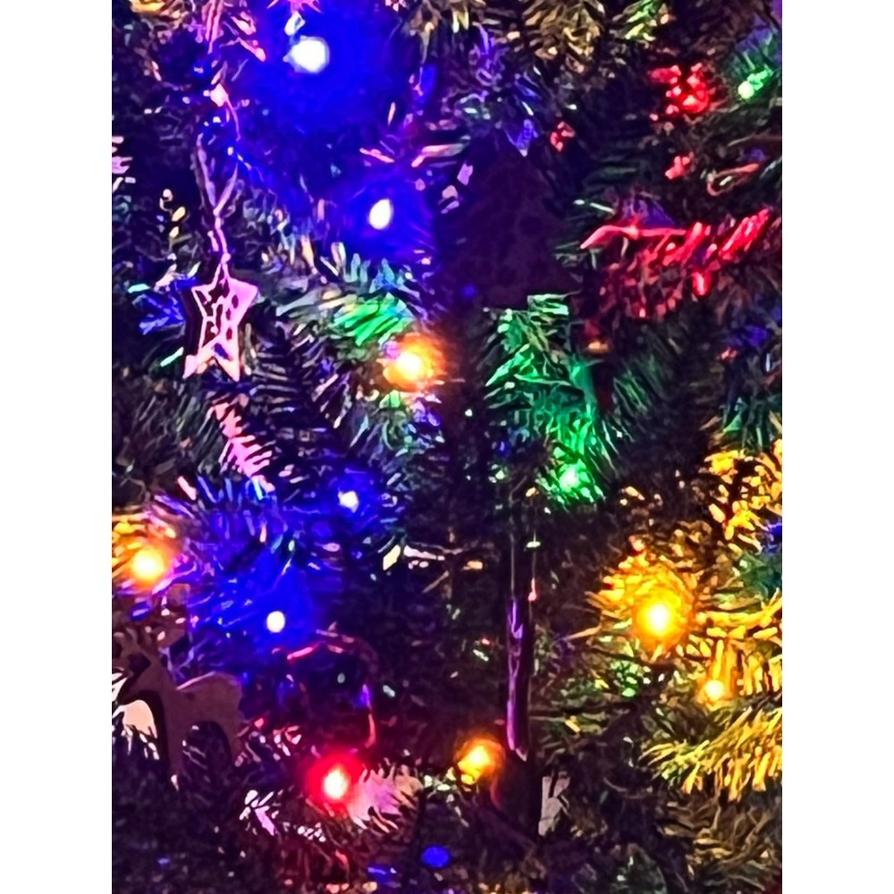 Customer close-up of multicoloured lights and green foliage on a HOMCOM pencil Christmas tree