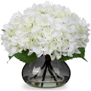 White artificial hydrangeas in a smoky glass vase with faux water
